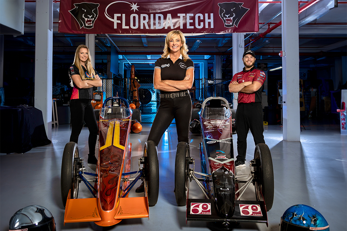 Elaine Larsen, front, works extensively with the drivers, Josette Roach, left, and Zach Costello, of House of Kolor and Florida Tech jet dragster teams.