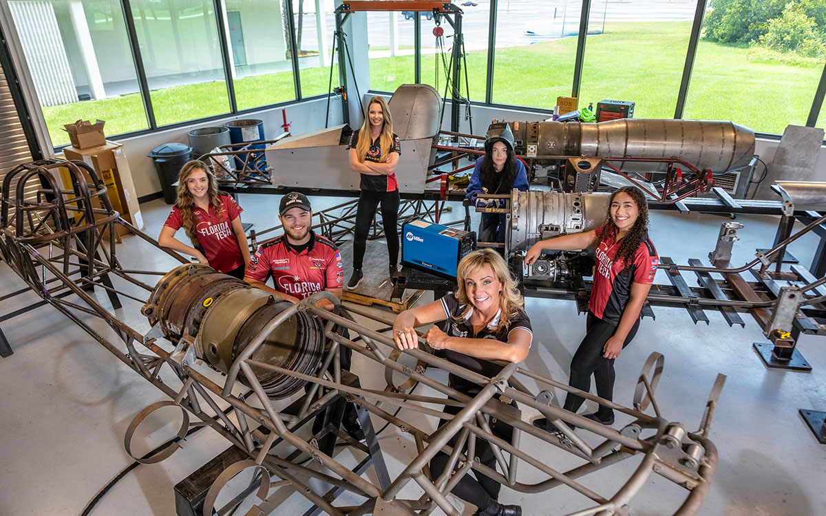 Elaine Larsen, front, works with drivers Costello and Roach, back row, as well as interns Graham, Holly Grant and Alana Martin. She is grateful to have the resources and technology offered through the Florida Institute of Technology-Larsen Motorsports collaboration.