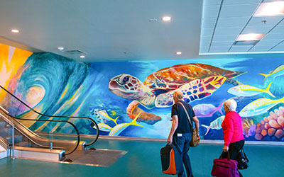 A bright and colorful mural at the airport’s new escalator captures the wonder of sea turtles.