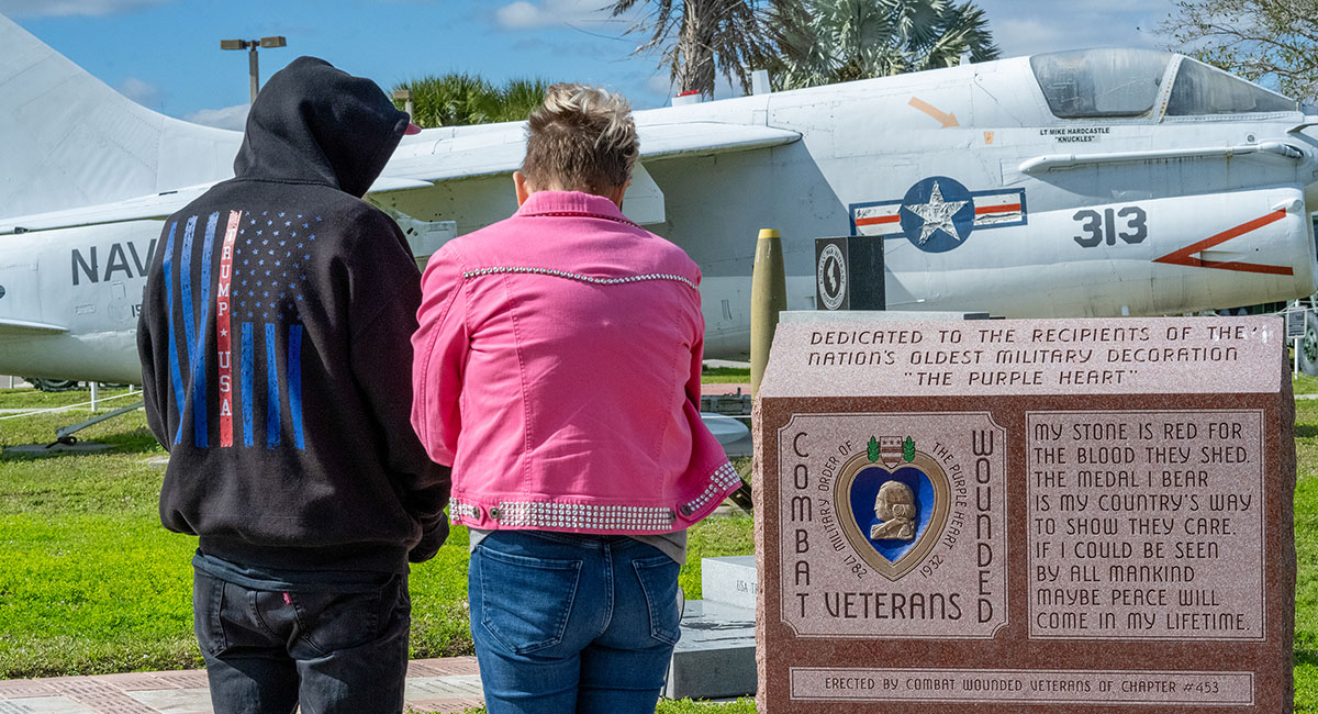 Visitors pause to reflect at a monument dedicated to recipients of the Purple Heart