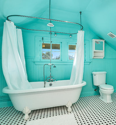 The brightly-colored bathroom in the upstairs Dove Suite includes an old-fashioned clawfoot tub, and tongue-and-groove paneling.