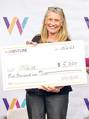 Woman holding a a big check for five thousand dollars