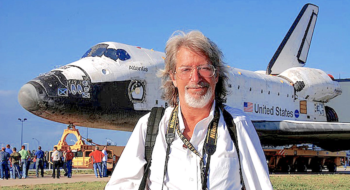 Photographer Lloyd Behrendt stands before the Atlantis Space Shuttle, one of the other famous metal birds he often photographed